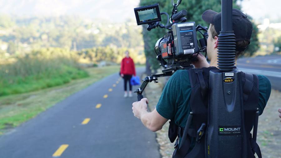 student filming person on road